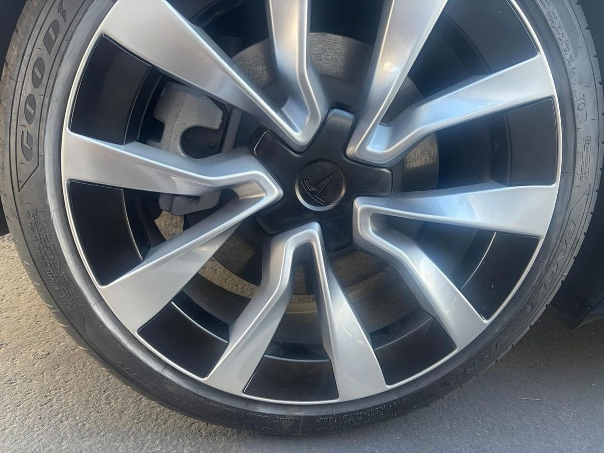 Silver Tesla wheel after curb rash repair